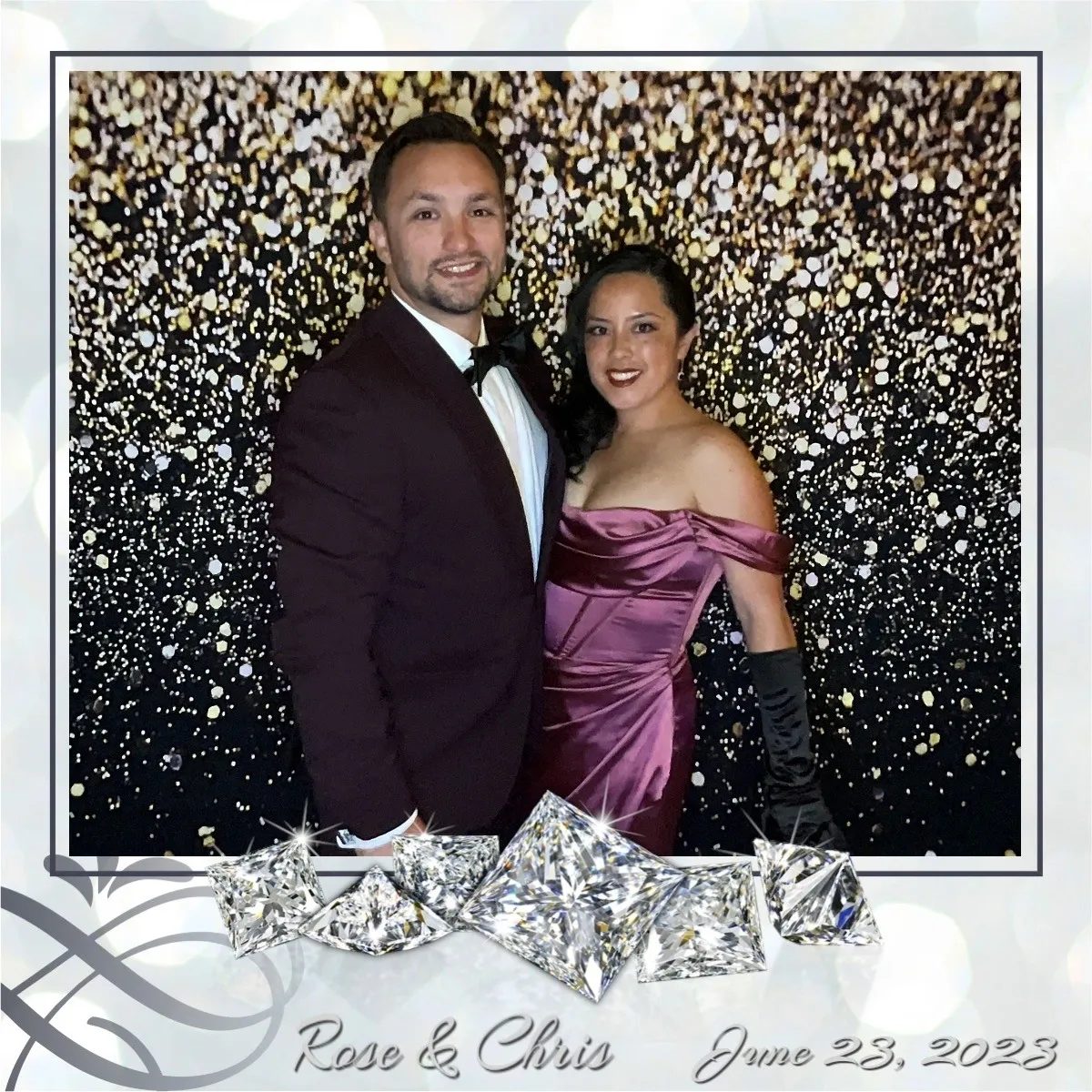 A man and woman posing for a picture in front of a wall covered with silver foil.