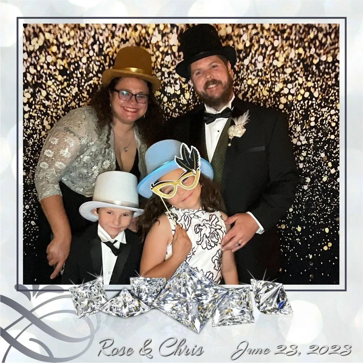 A family posing for a photo in front of a silver background.