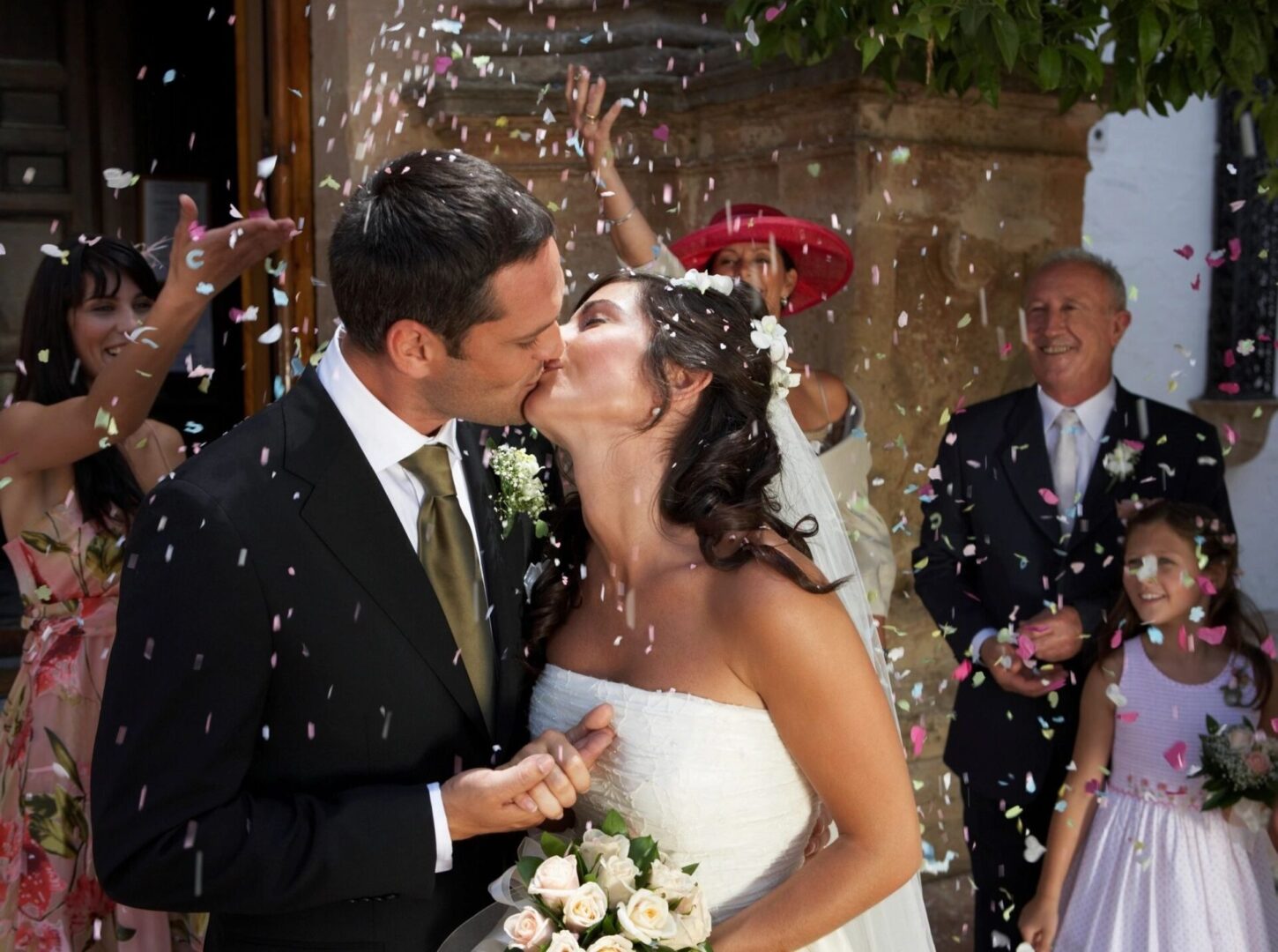 A bride and groom kissing in front of a crowd.