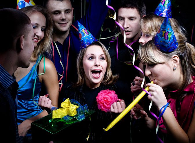 A group of people with party hats and streamers.